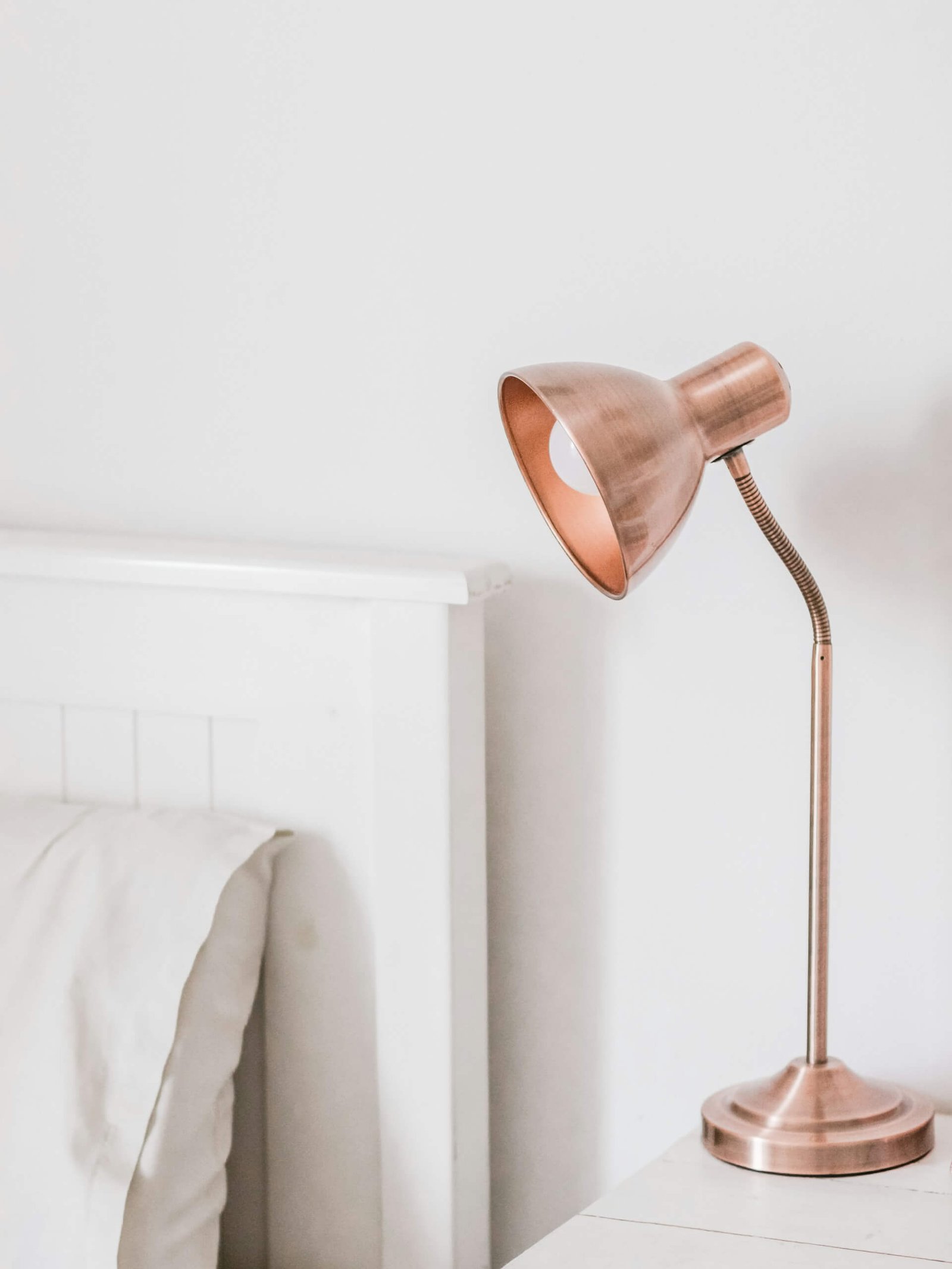 a copper lamp on nightstand