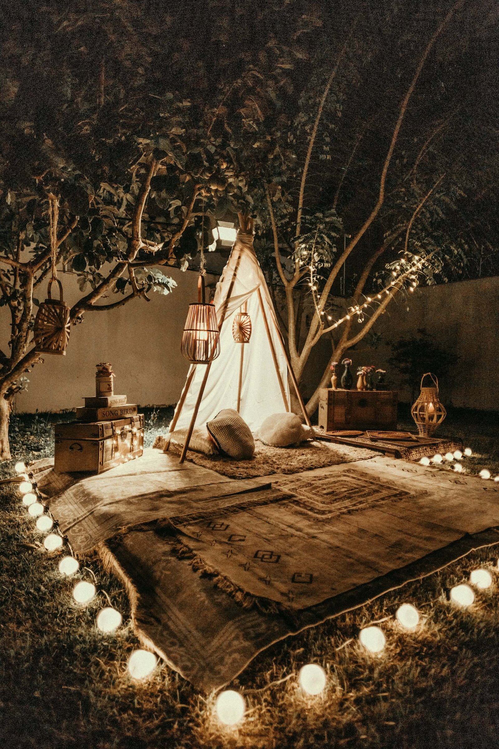a string of lights surround a small tent with a blanket